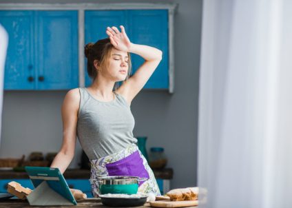 Woman experiencing holiday back pain from cooking and stress